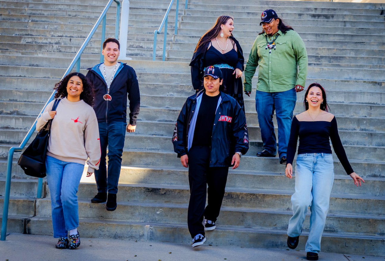 Students walking in a group down stairs outside in a candid photo