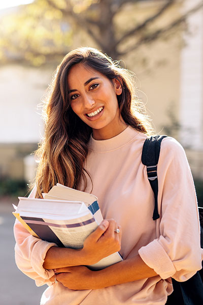 woman holding textbooks