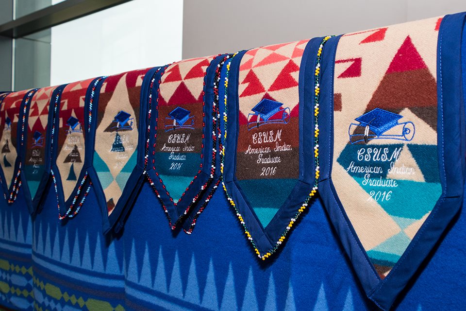 CSUSM American Indian Graduate 2016 Stoles draped in a line over a table with a blue tablecloth