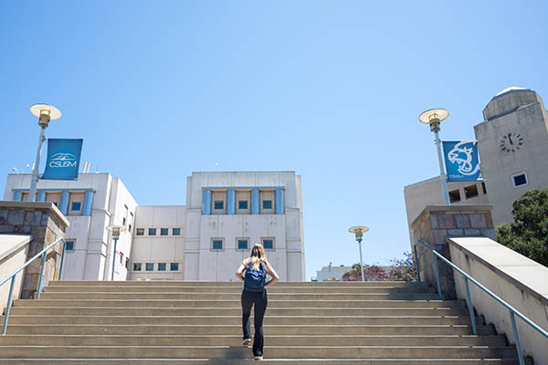 student walking up steps to campus