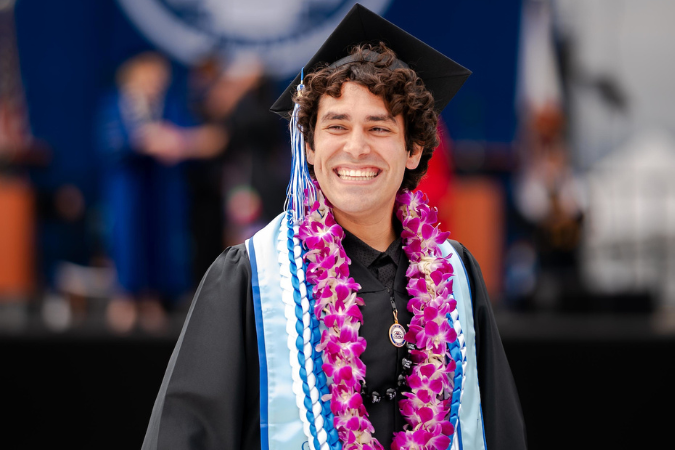 CSUSM Graduate at Spring Commencement wearing a double orchid lei The Commencement Group - Flowers and Leis