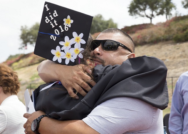 family hugging graduate