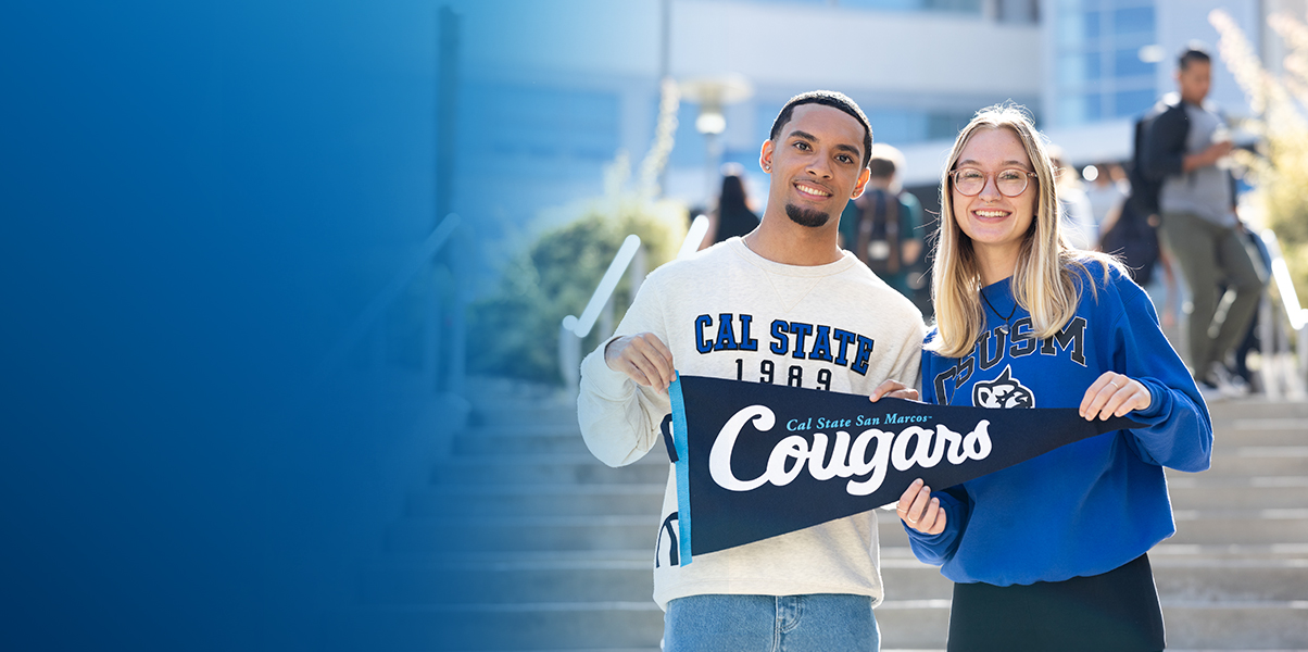two students holding a CSUSM pendant