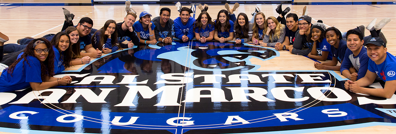 photo of o-team around cougar logo in the sports arena