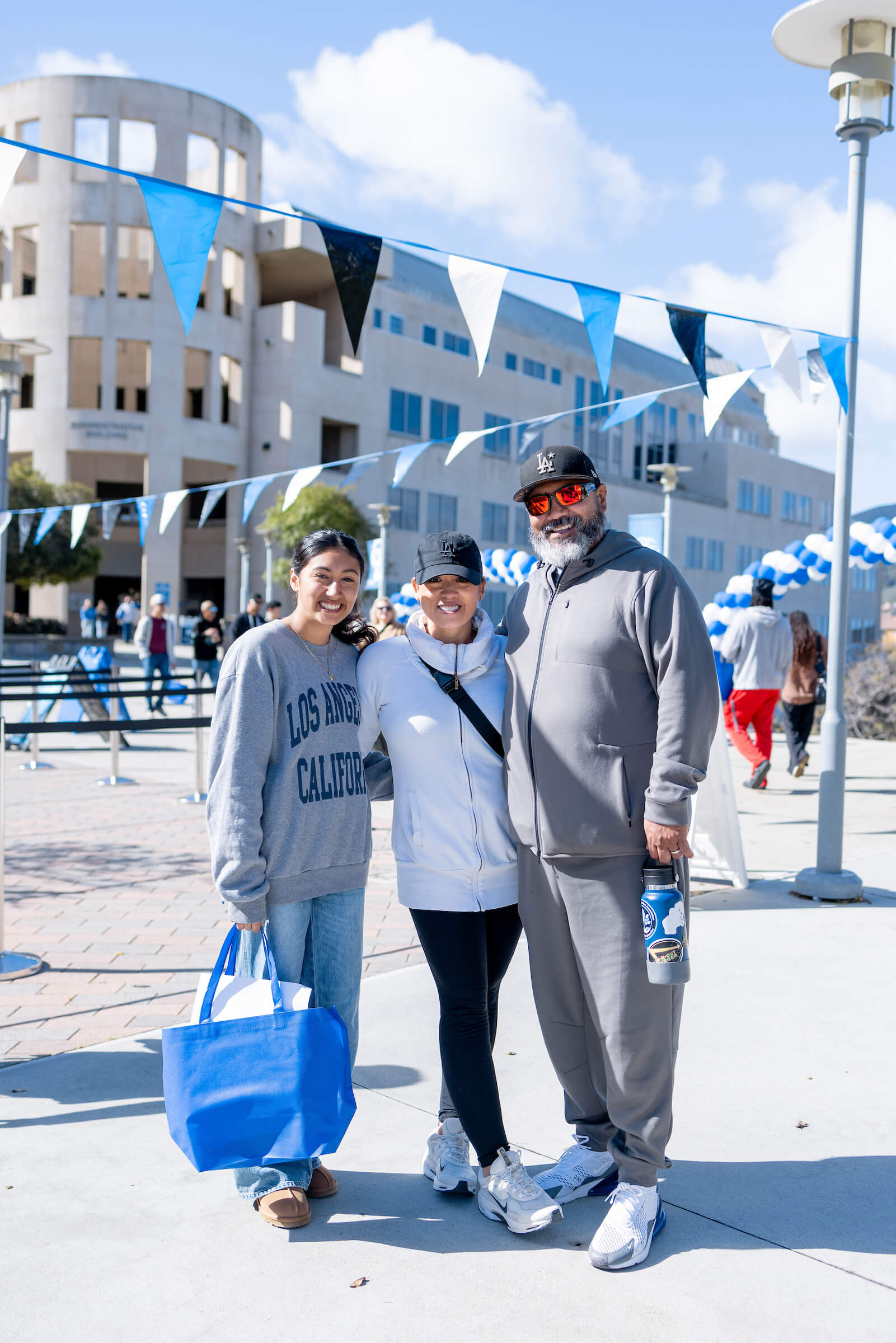 Hispanic family holding up a sign of I love CSUSM