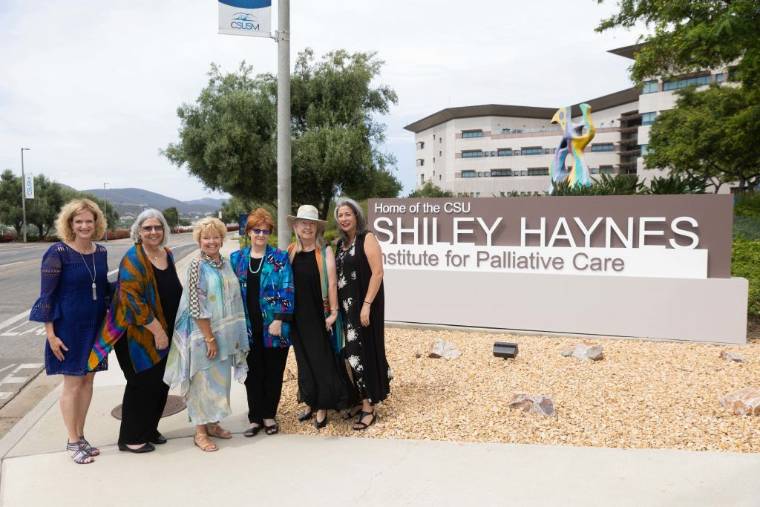 CSUSM President Emerita Karen Haynes with others in front of new institute sign