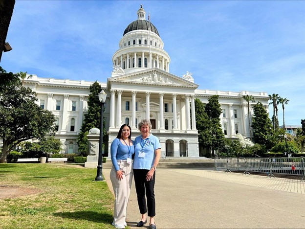 advocacy two women standing in front of state capitol building