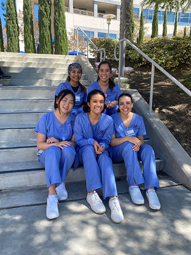 Nursing students sit on the stairs