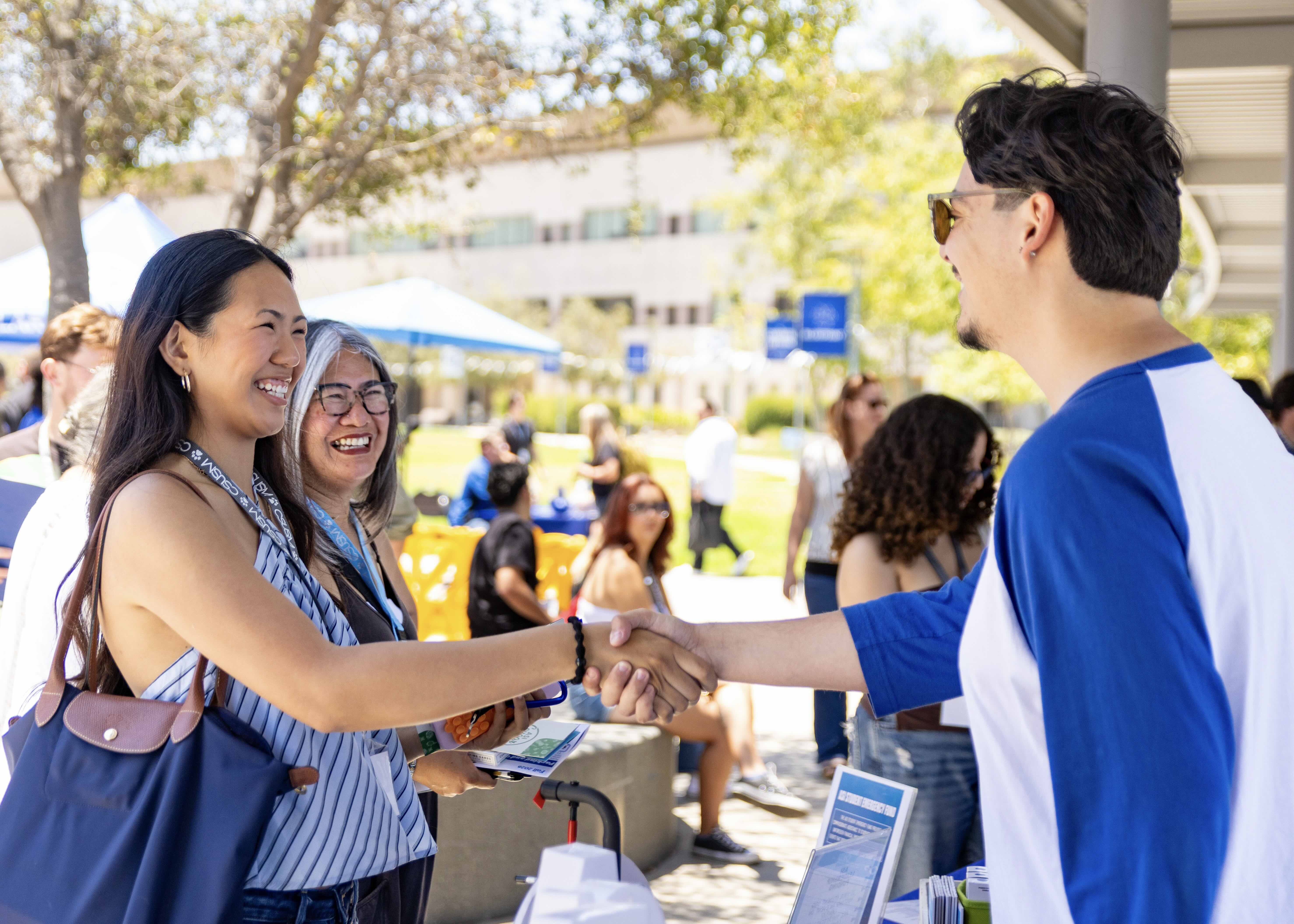 two people shaking hands smiling
