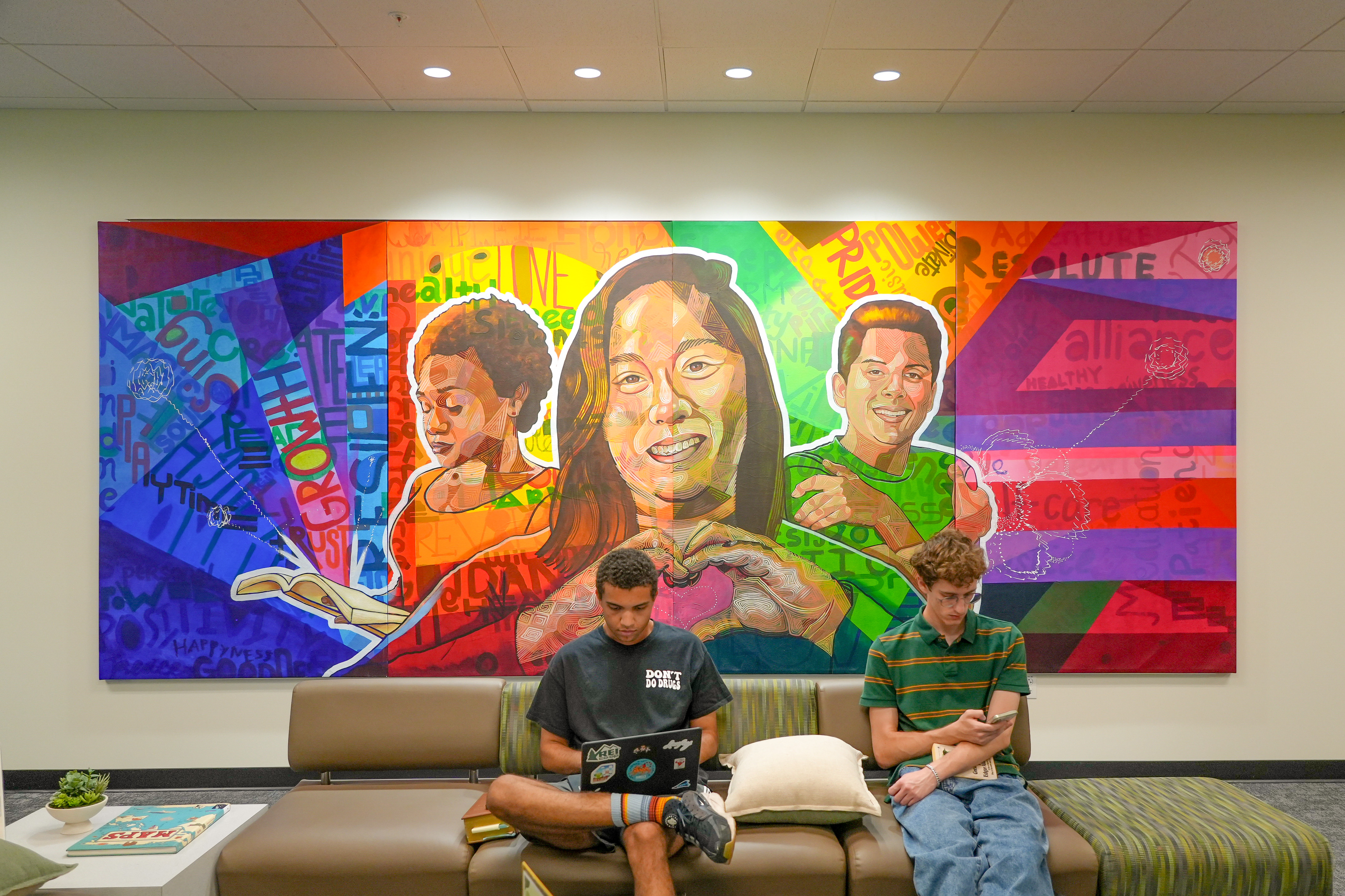 students sitting in front of a mural