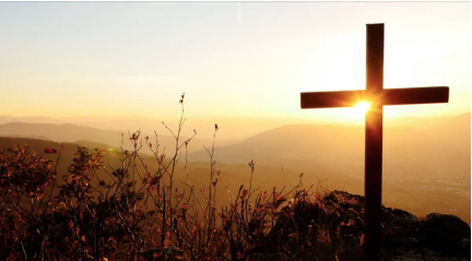 cross on a hill at sunset