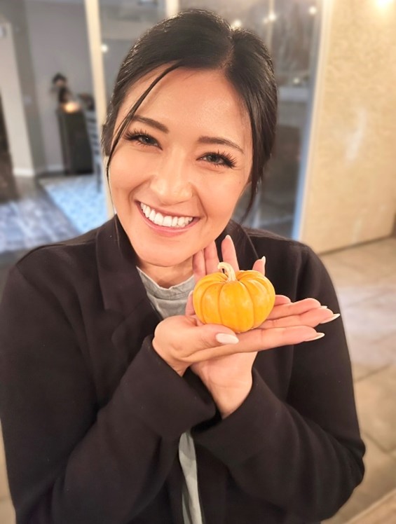 Joane Macias holding a small pumpkin