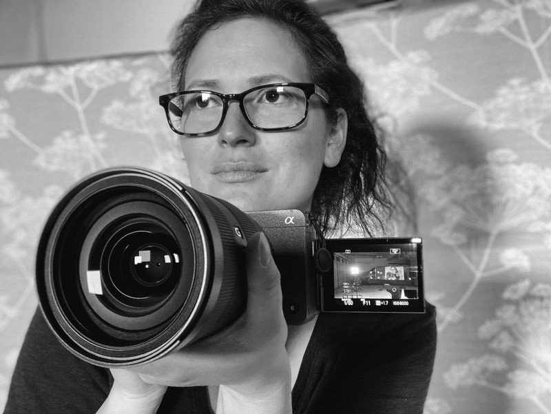 Black and white portrait of Nicole with her camera