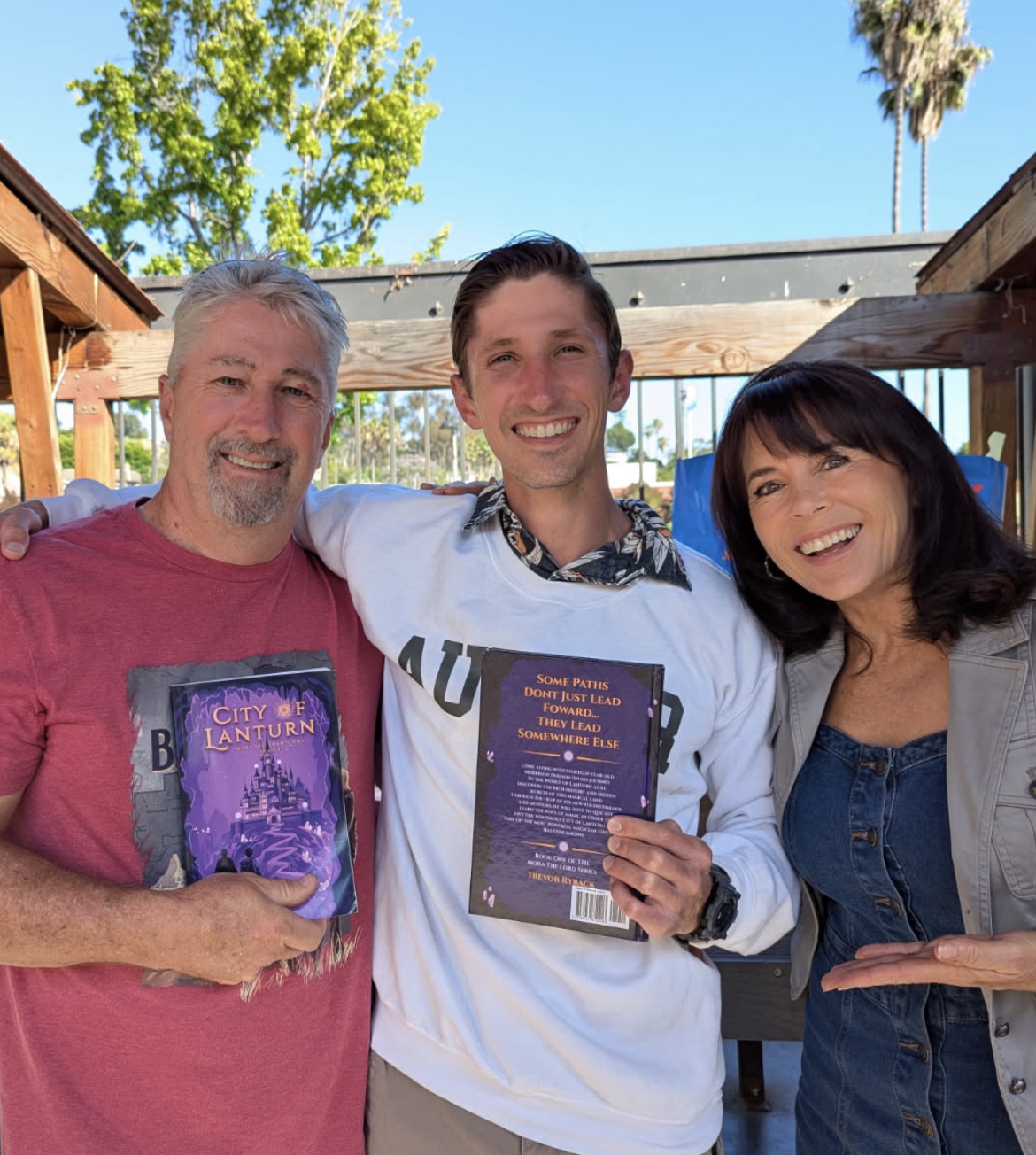 Three people holding up a book
