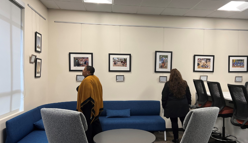 Two employees viewing art on the wall.