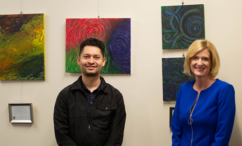 two people posing in front of abstract art