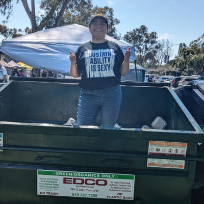 Woman is dumster giving two thumbs up