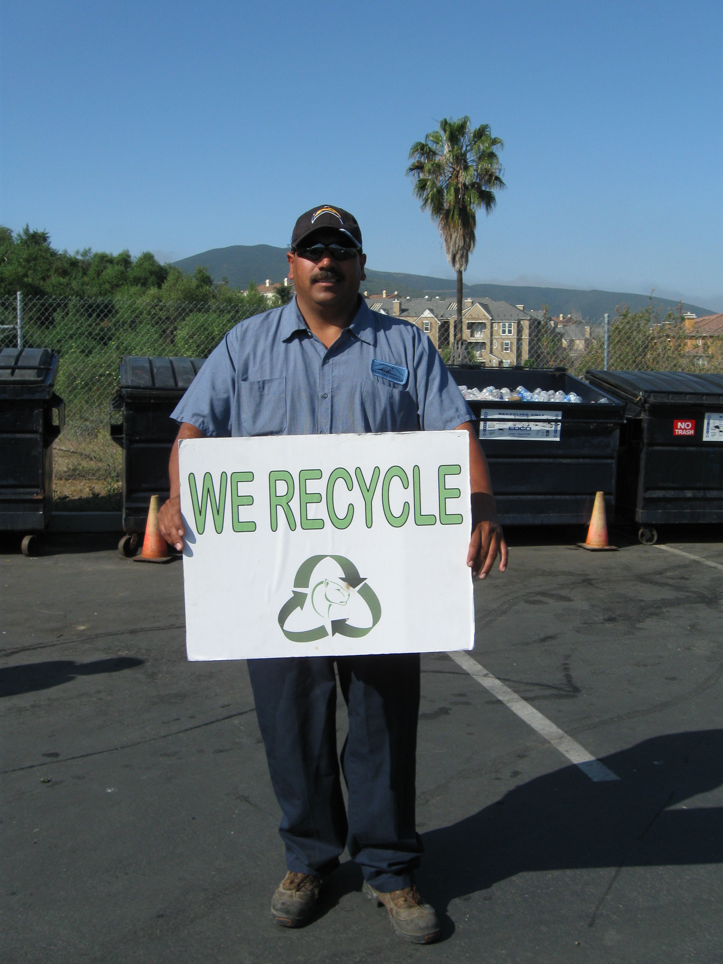 Man holding up sign that say "we recycle"
