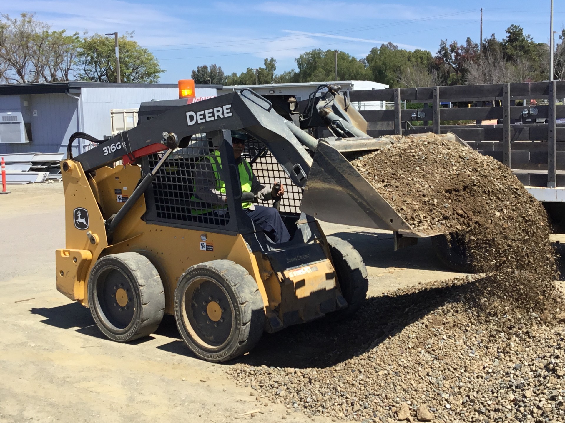 man in a yellow tractor picking up sand