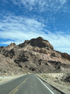 Desserted road headed towards a barren hill.
