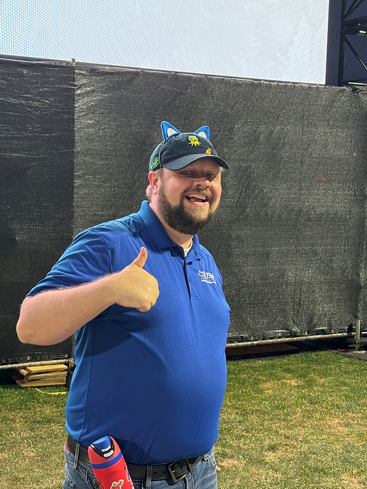 Man in a blue shirt with a thumbs up