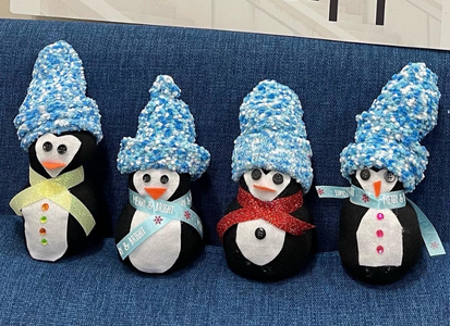 Fiyr crafted penguins on a blue couch