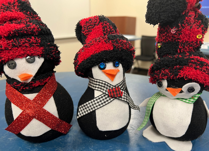 three crafted penguins with red sock hats