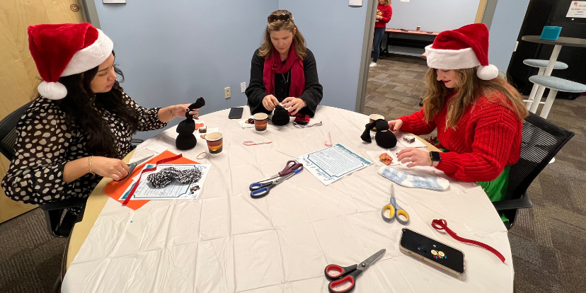 Staff around a table crafting their penguins.