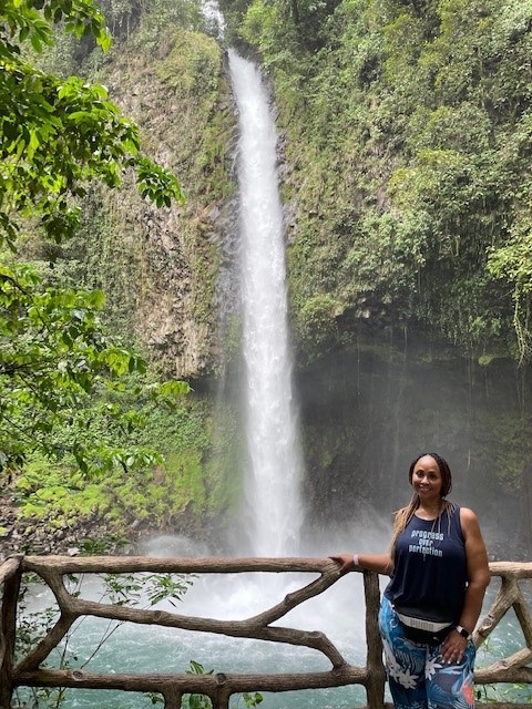 Kimberly posing in front of a beautiful waterfall in Costa Rica.