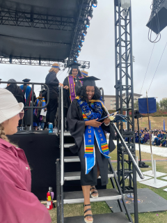 Talisha walking down the steps of the Commencement stage.