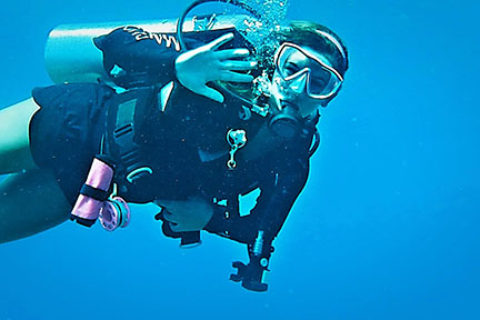 Dani underwater diving waving at camera